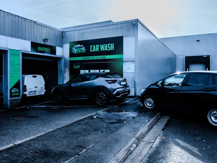Entrée d'une station de lavage partenaire, voitures en attente